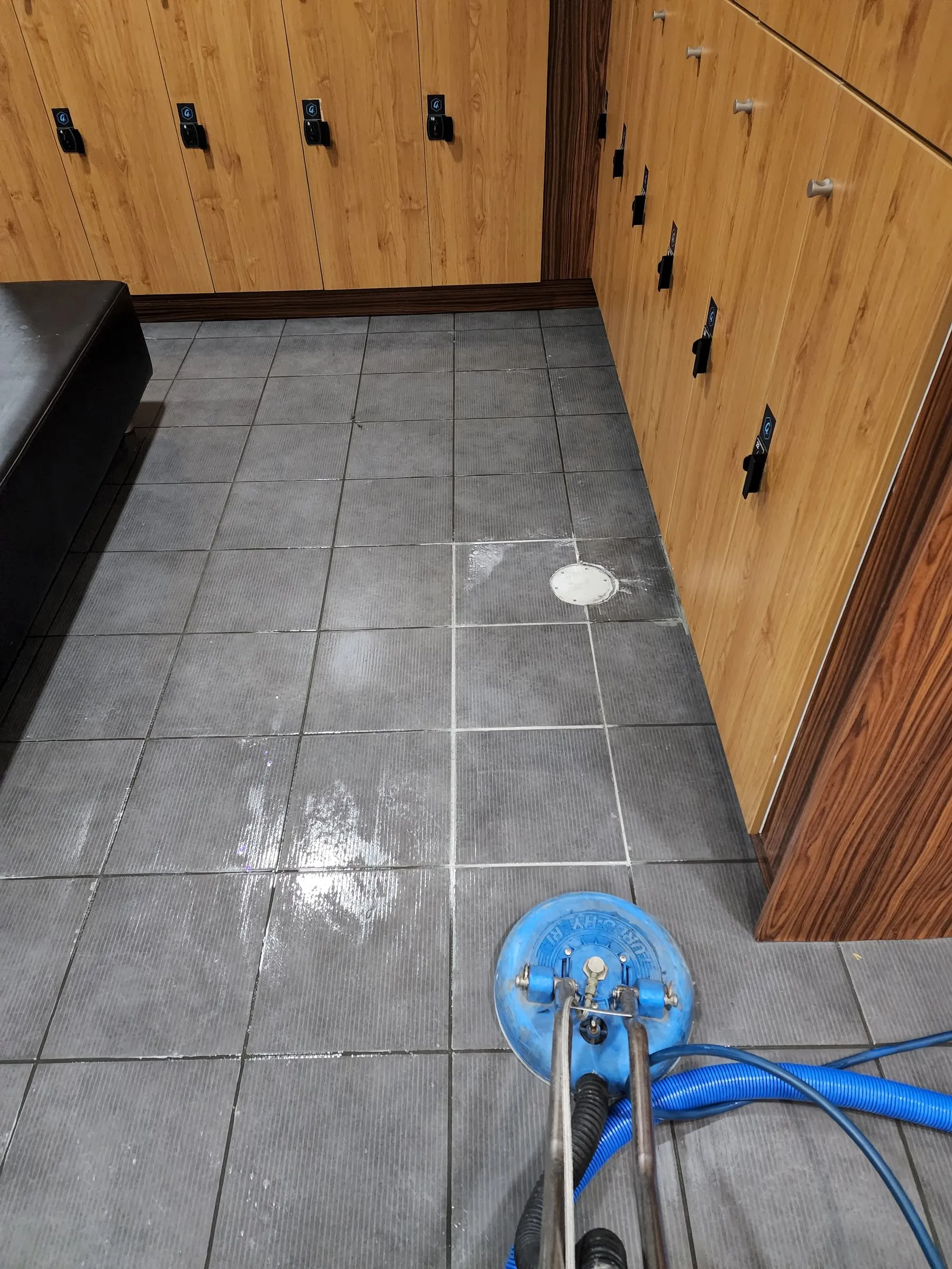 Change room tiles freshly scrubbed beside timber lockers