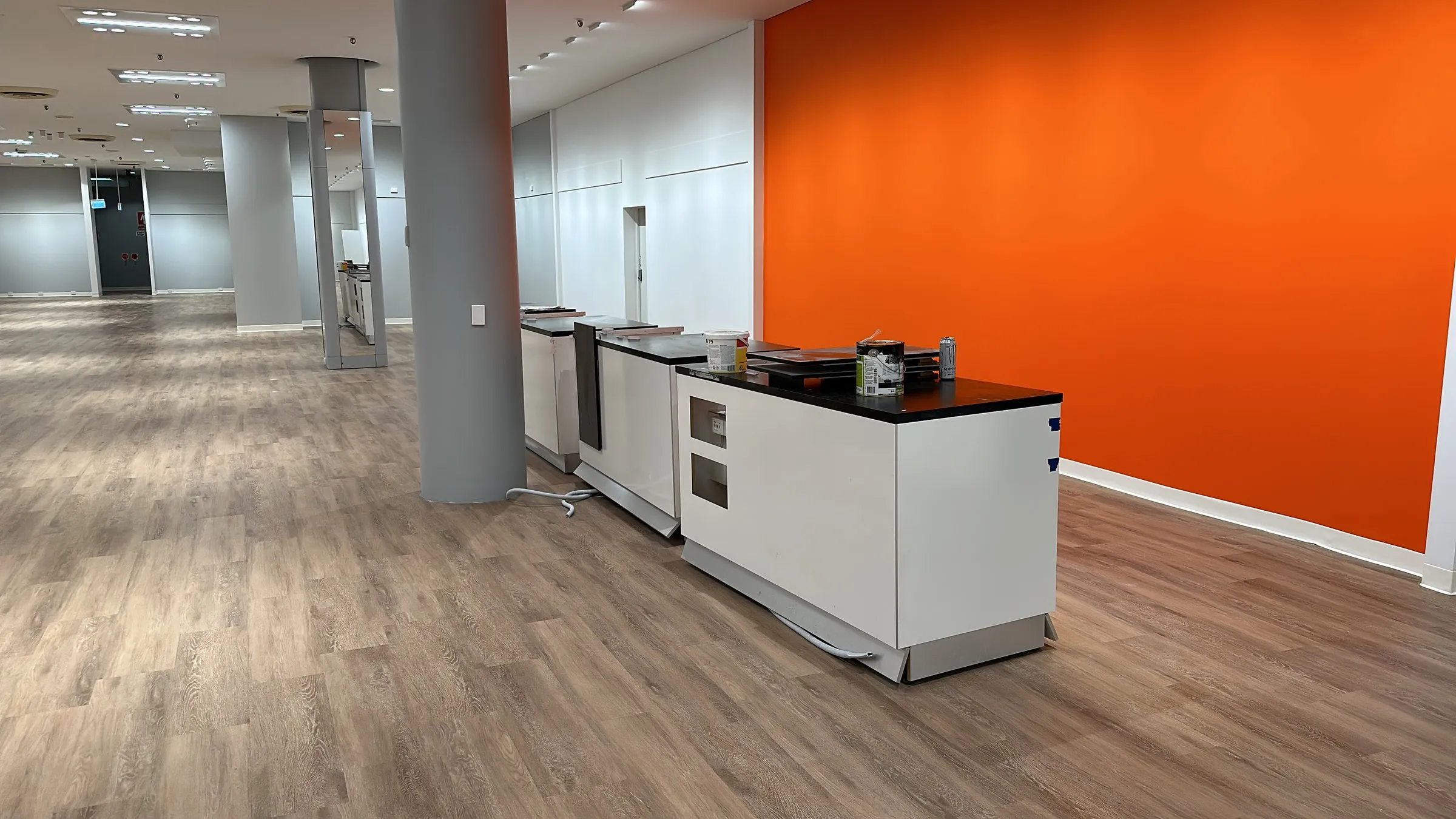 Clean office kitchen with an orange feature wall