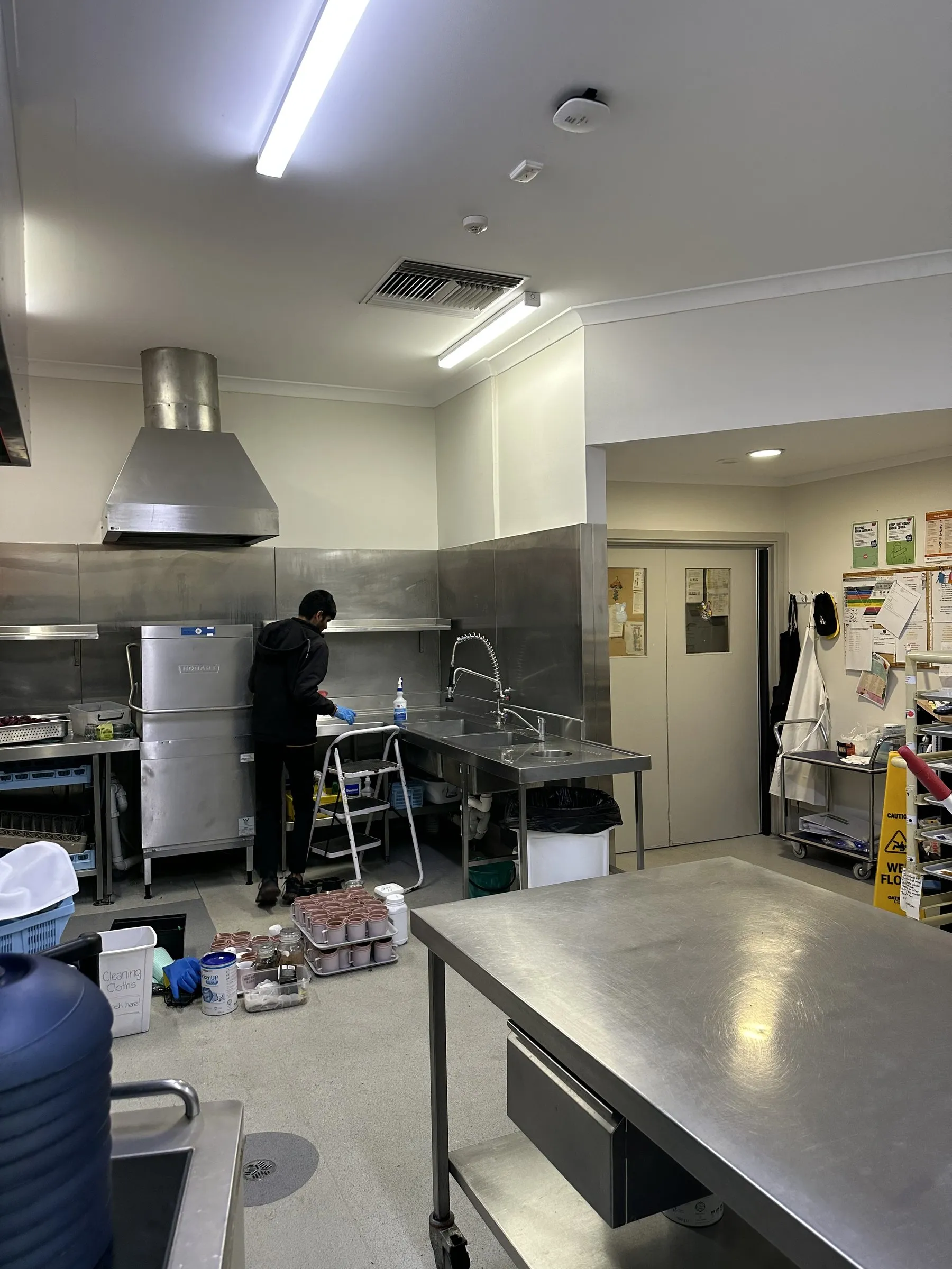 Commercial kitchen deep clean in progress at stainless benches