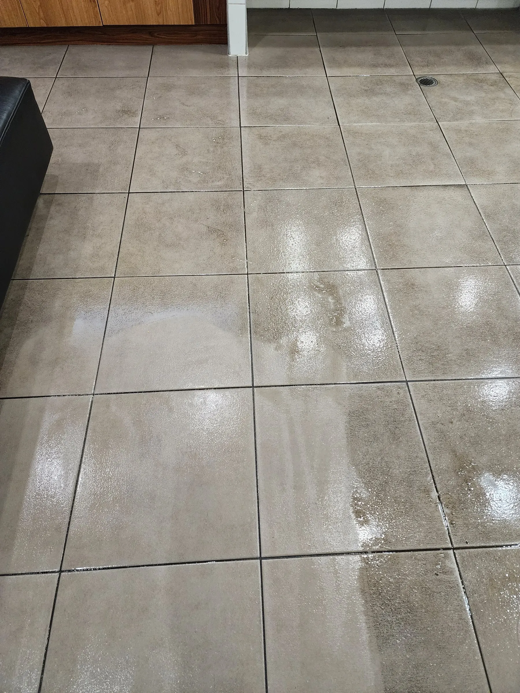 Large grey floor tiles shining after a scrub