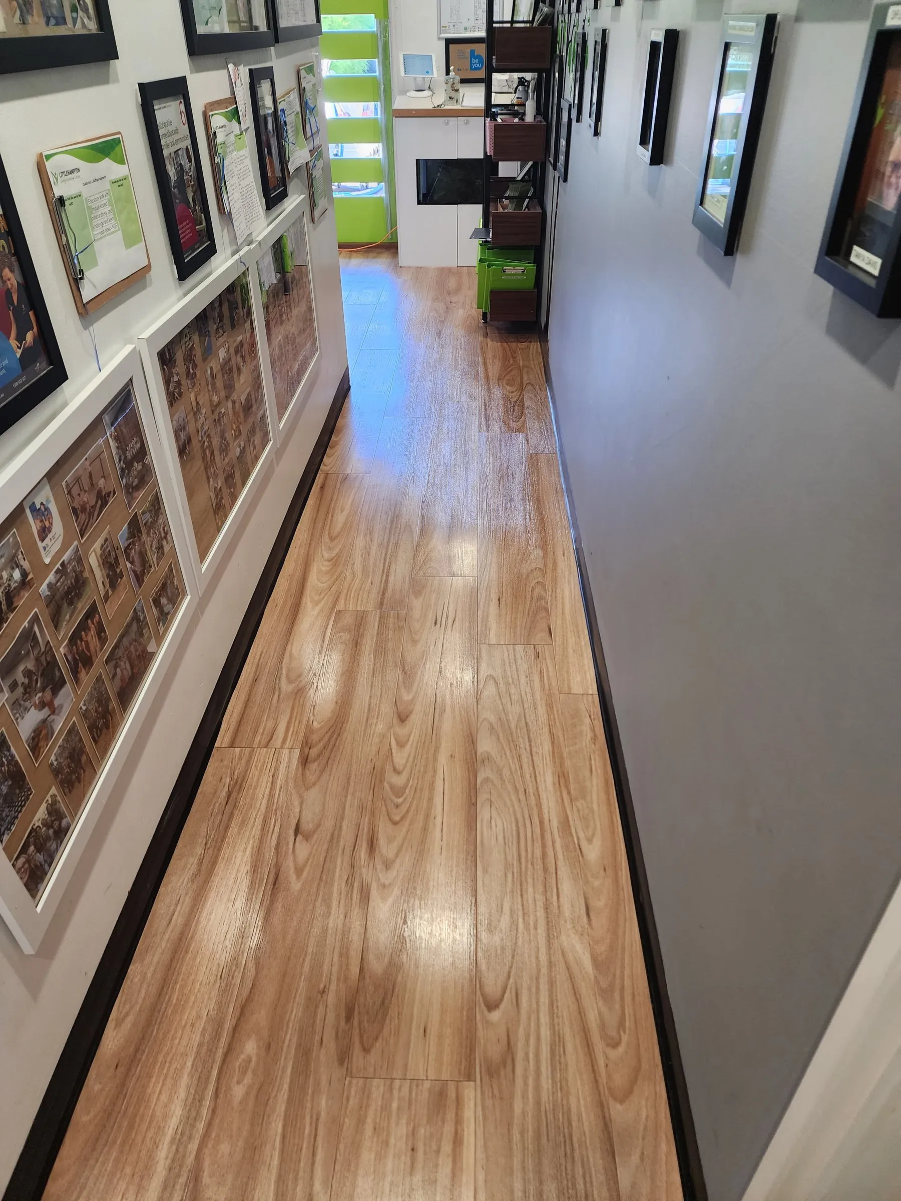 Office hallway with artwork and a gleaming timber floor