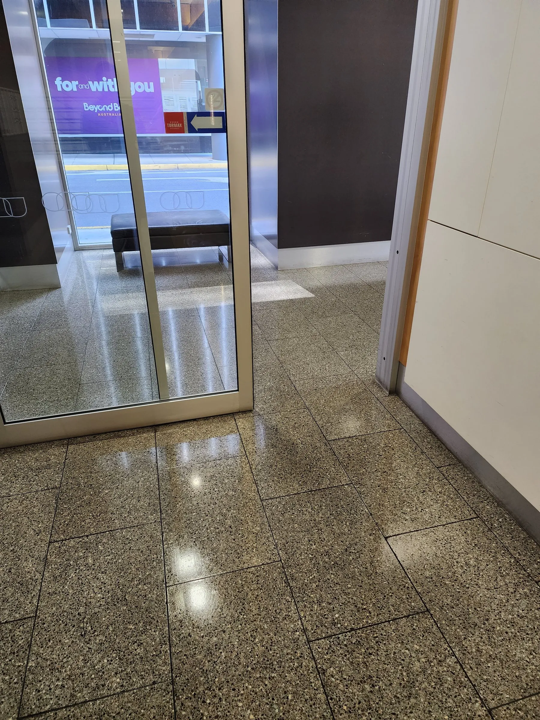 Glass shopfront entry over a terrazzo floor