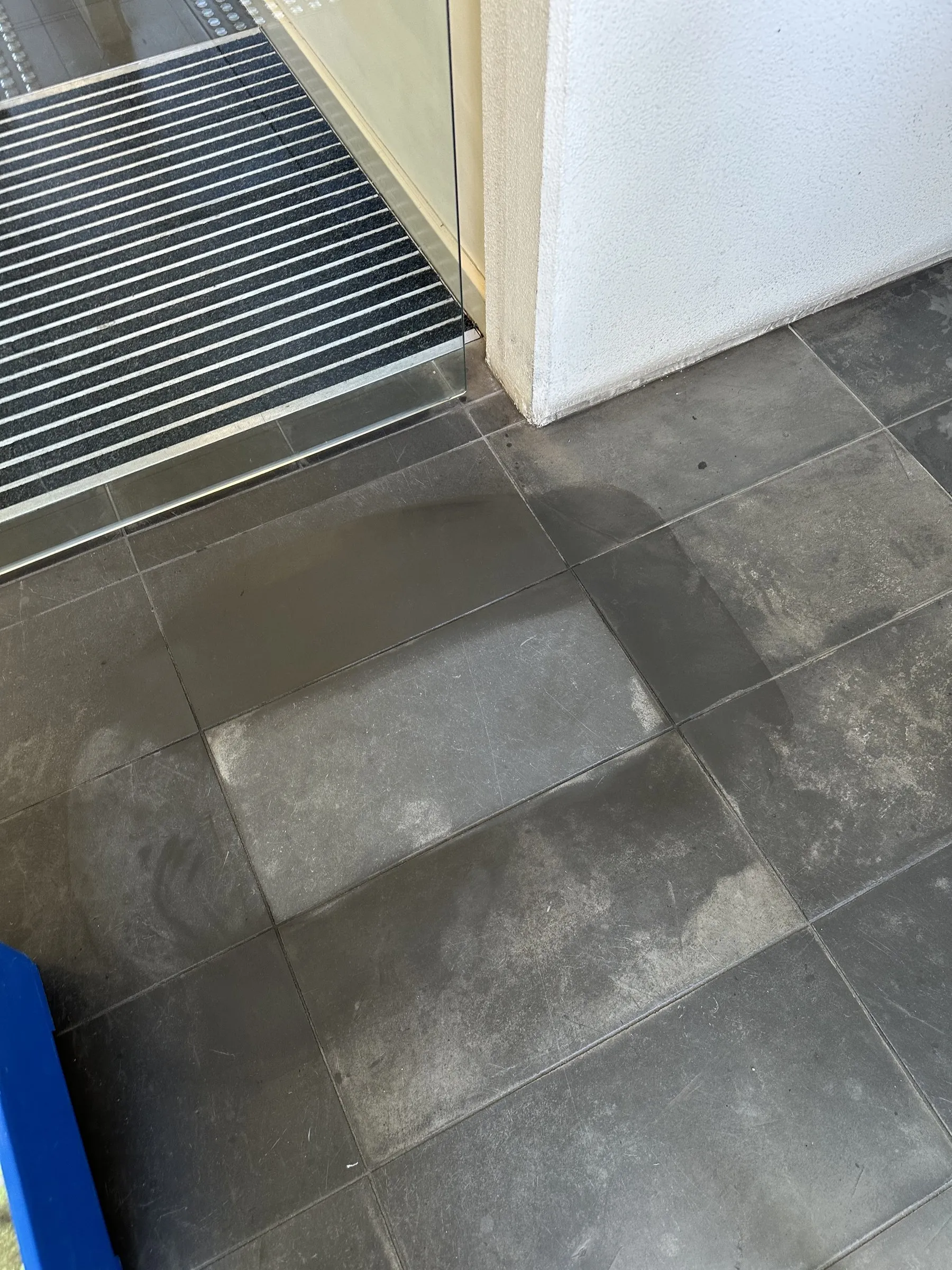 Clean grey tile floor beside an entry mat
