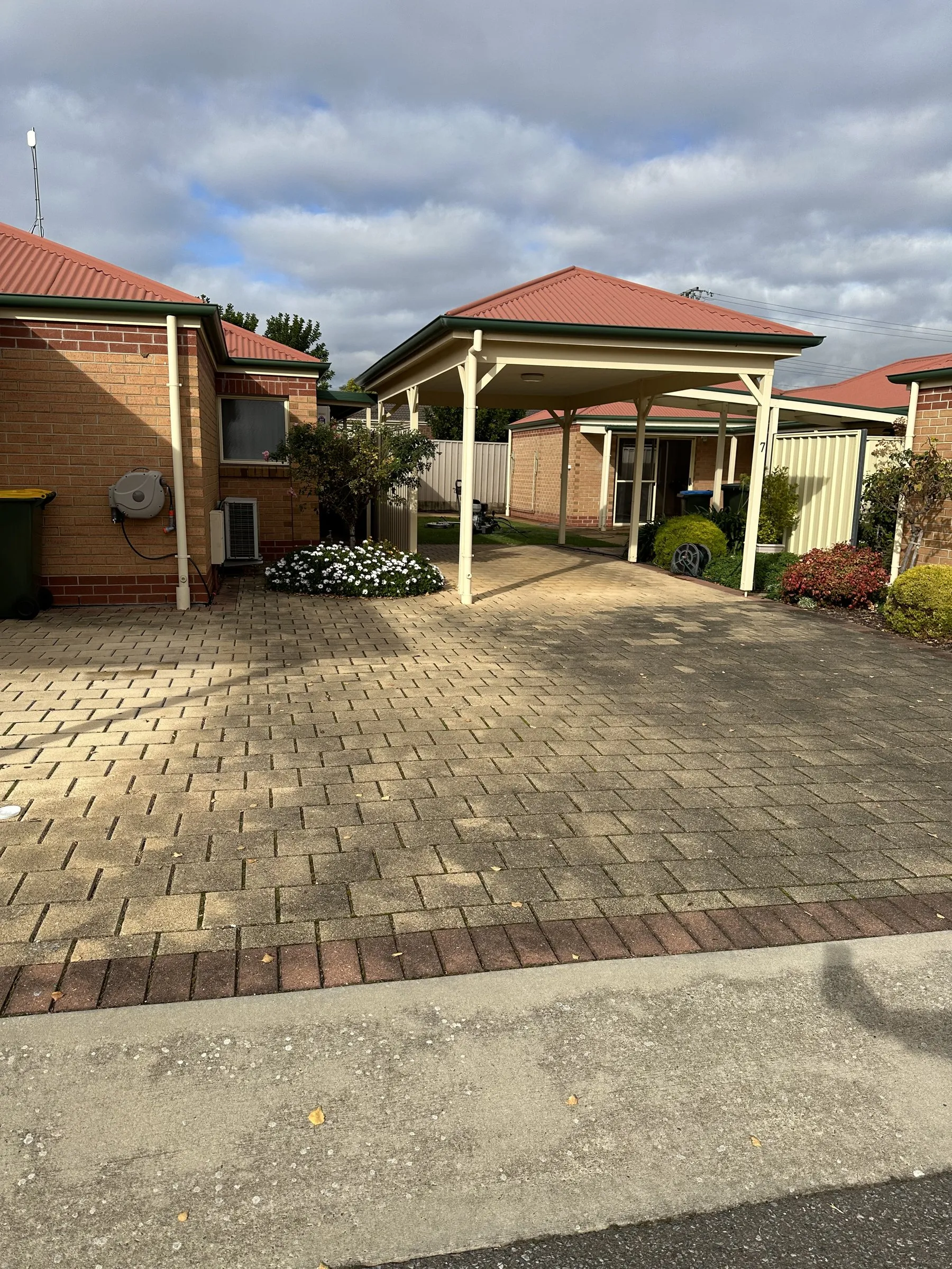 Unit courtyard with brick pavers and a pergola